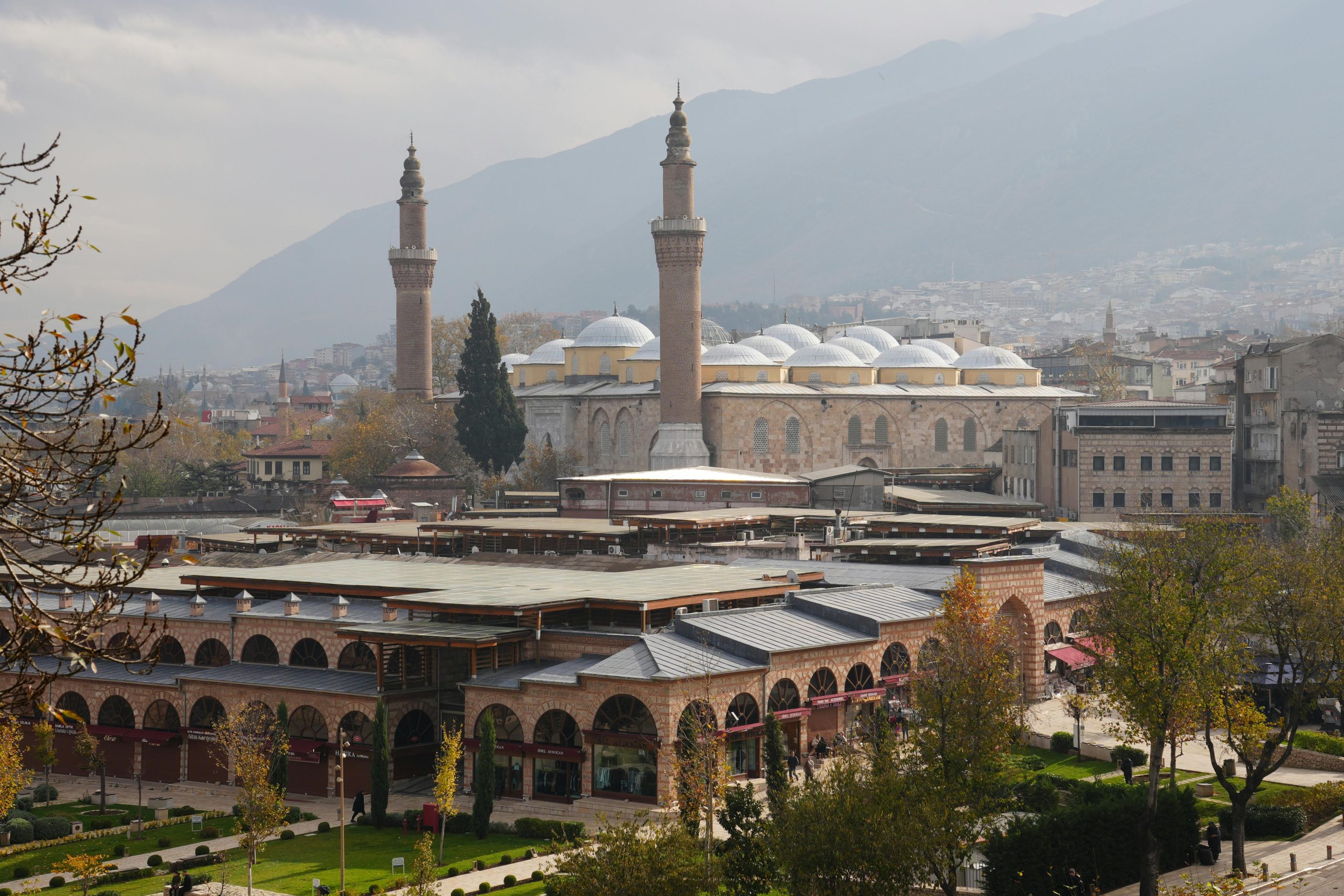 Historic Bursa mosque illuminated at dusk with Mount Uludağ rising in the background