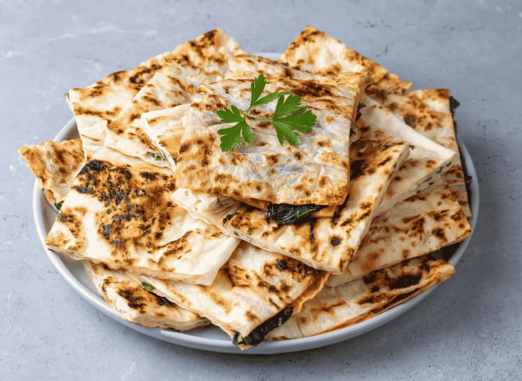 Handmade Turkish gözleme flatbread filled with spinach and cheese cooked on a sac griddle