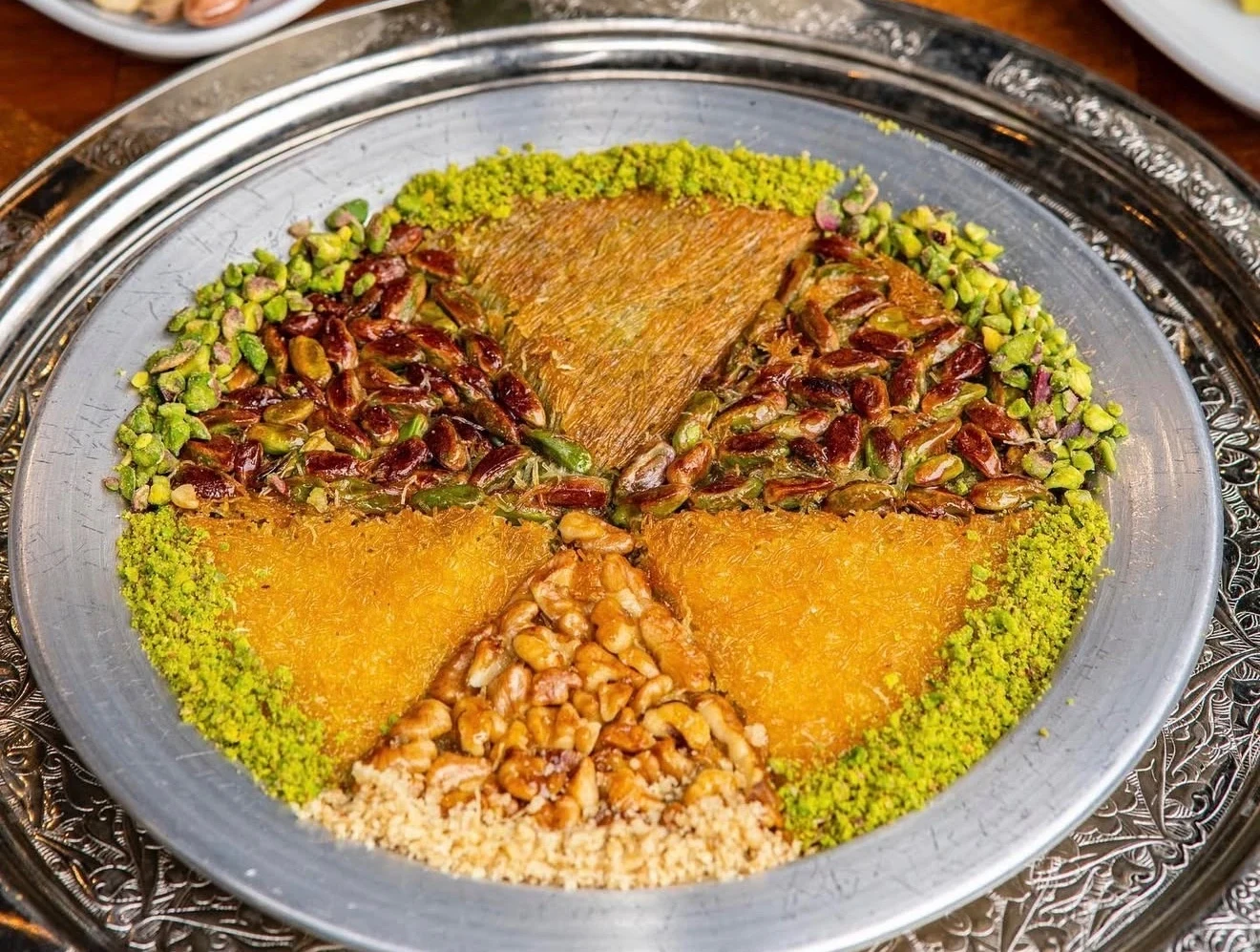 Hot Turkish künefe dessert with stretchy cheese, kadayıf pastry, syrup, and pistachios