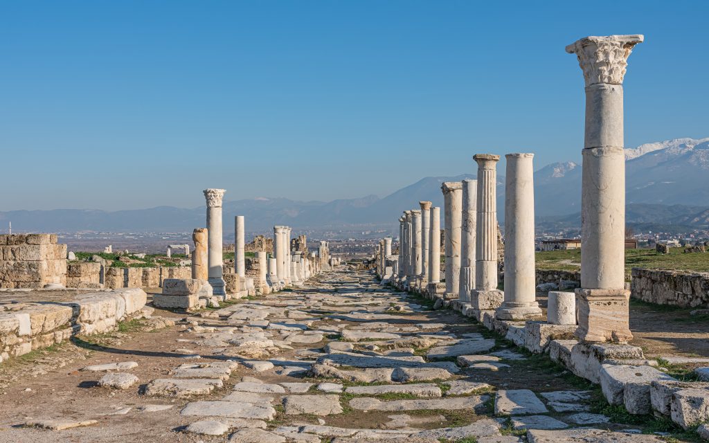 Laodicea Ancient Colonnaded Street near Pamukkale Turkey Laodicea ancient colonnaded street with marble columns and snow-capped mountains near Pamukkale Turkey