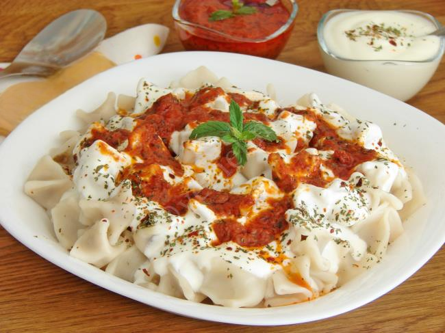 Turkish mantı dumplings with garlic yogurt, melted butter, and dried mint on top