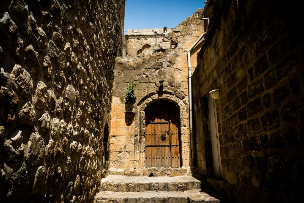 Honey-colored limestone houses of Mardin old city overlooking the Mesopotamian plain at golden hour