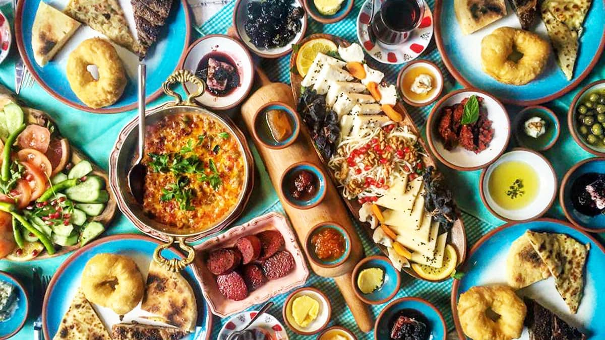 Traditional Turkish kahvaltı breakfast spread with cheese, olives, eggs, jams, and tea