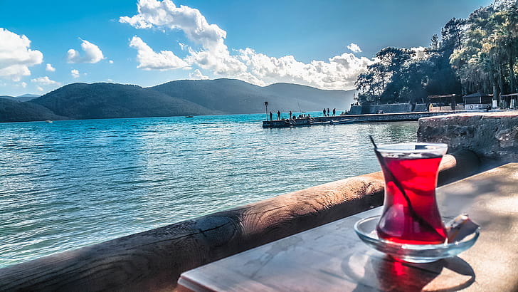 Turkish tea in a tulip-shaped glass beside a small cup of Turkish coffee with lokum