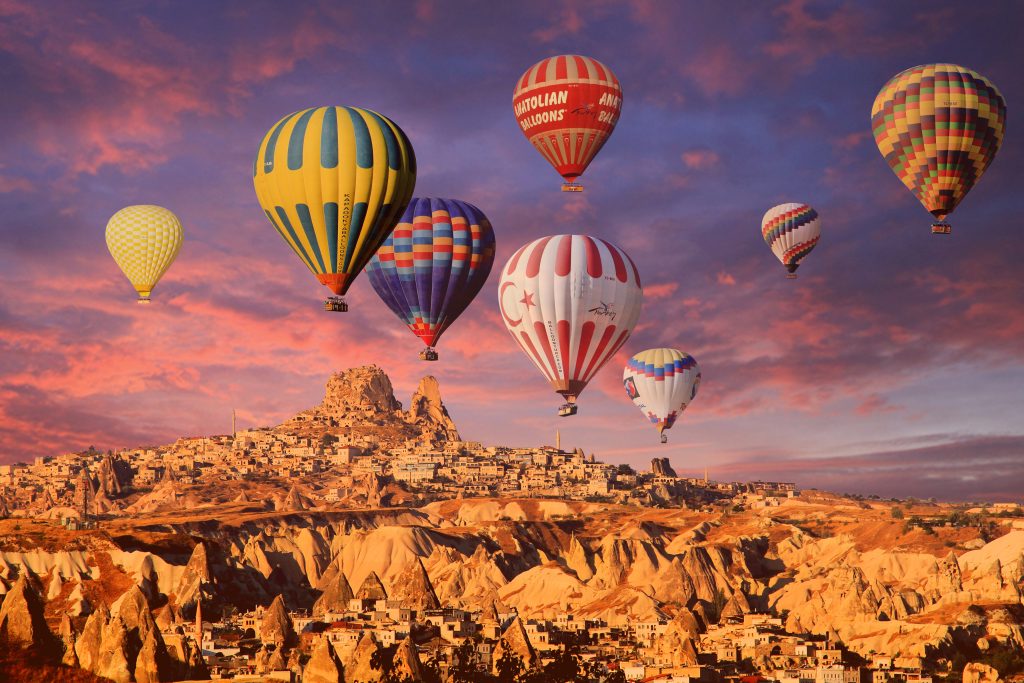 Cappadocia hot air balloons at golden hour with pink and orange light on the fairy chimneys ideal for photography