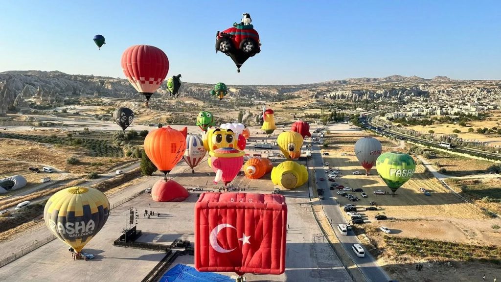 Special-shape festival balloons during BalonFest Kapadokya at the Göreme launch field with regular passenger balloons