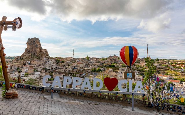 Cappadocia hot air balloons rising over fairy chimneys at sunrise in golden morning light