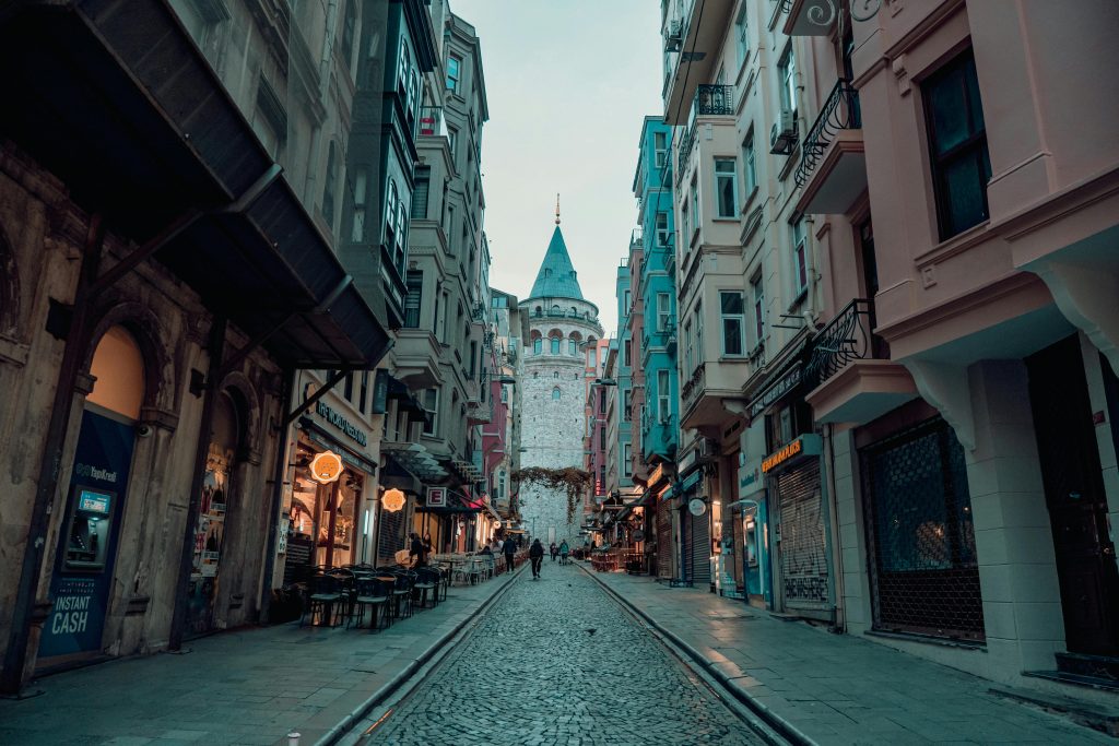 Cobblestoned Karaköy street in Istanbul with Galata Tower in the background at evening